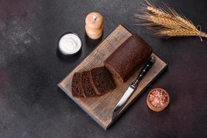 Sliced rye bread on cutting board. Whole grain rye bread with seeds photo