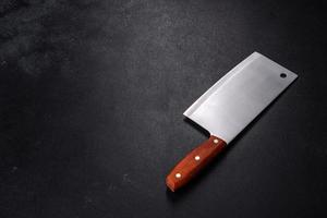 An axe for cutting meat on a dark concrete background photo