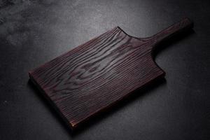 An empty plate with a knife, fork or spoon with a wooden cutting board photo