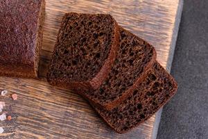 Sliced rye bread on cutting board. Whole grain rye bread with seeds photo