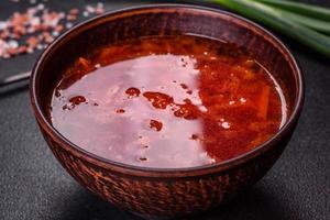 Traditional Ukrainian borsch. Bowl of red beet root soup borsch with green onion photo