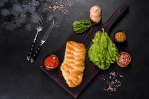 Traditional Ukrainian cabbage pie on a dark concrete background. Baked homemade pie with cabbage photo
