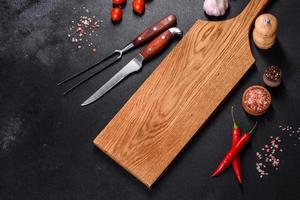 An empty plate with a knife, fork or spoon with a wooden cutting board photo