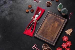 Christmas table setting with empty black ceramic plate, fir tree and black accessories photo