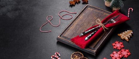 Christmas table setting with empty black ceramic plate, fir tree and black accessories photo
