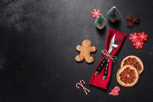 Christmas table setting with empty black ceramic plate, fir tree and black accessories photo