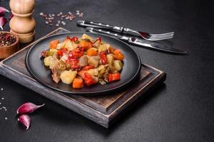 Vegetable stew or ratatouille with eggplant, tomatoes, sweet and hot peppers, onions, carrots and spices in plate photo