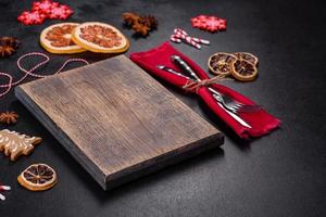 Christmas table setting with empty black ceramic plate, fir tree and black accessories photo