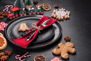 Christmas table setting with empty black ceramic plate, fir tree and black accessories photo