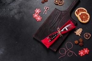 Christmas table setting with empty black ceramic plate, fir tree and black accessories photo
