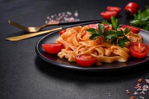 Tasty appetizing pasta tagliatelle spaghetti with tomato sauce and parmesan photo