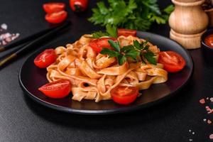 Tasty appetizing pasta tagliatelle spaghetti with tomato sauce and parmesan photo