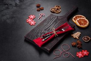 Christmas table setting with empty black ceramic plate, fir tree and black accessories photo
