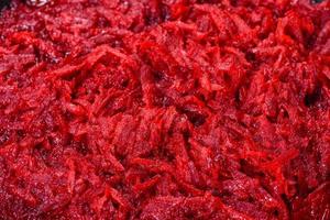 Chopped beetroot in a pan as well as spices and herbs on a wooden cutting board photo