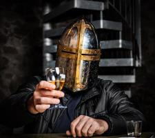 A man in a medieval iron knight's helmet. photo