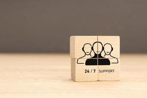 24-7 Customer support concept. Group of wooden block with Group of Call Center Workers icon. Copy space photo
