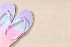 Summer background with fashion flip flops on beach sand background. Copy space. Top view photo