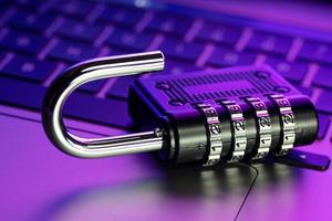 Computer Security Vulnerability concept. Open padlock on laptop with colorful lights photo