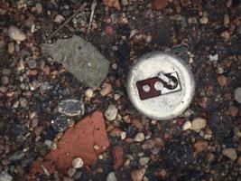 Old corroded steel metal switch with lever lying on black ground in trash with broken red brick parts and pebbles photo