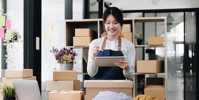Small start-up business owners using computers at work, freelancers, saleswoman, checking production orders. Pack products for delivery to customers sell ecommerce delivery ideas photo