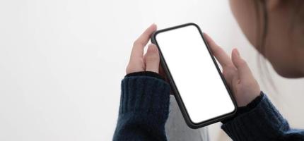 Top view of woman hands holding smart phone with blank copy space screen for your text message or information content. photo