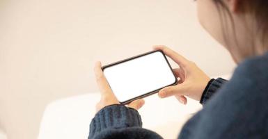 Top view of woman hands holding smart phone with blank copy space screen for your text message or information content. photo
