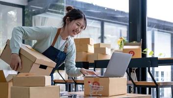 Starting small businesses SME owners female entrepreneurs check online orders to prepare to pack the boxes, sell to customers, sme business ideas online. photo