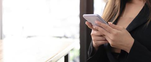 la mujer en casa usa un teléfono celular o un teléfono móvil. tecnología moderna en la vida cotidiana. foto