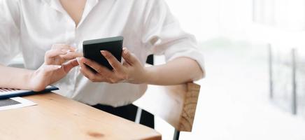 Close up hand of woman using smartphone at office. photo