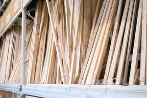 Wooden boards and bars in the warehouse of the building materials store for repair, decoration and construction of the house photo