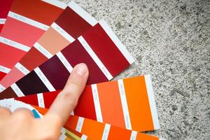 Selection of the paint color for decorative home repairs to the palette with layouts. A fan of shades in your hand inside the home. Repair and construction, paint and varnish coating photo