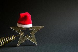 Gold transparent star with spangles in the shape of a Christmas tree on a black background. New year, Santa hat, gift, black Friday. Space for text photo