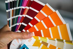 Selection of the paint color for decorative home repairs to the palette with layouts. A fan of shades in your hand inside the home. Repair and construction, paint and varnish coating photo