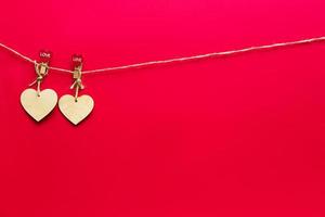 Garland of wooden hearts with clothespins with the inscription LOVE on a red background. Valentine's day, copy space, mock up. Holiday lights, flyer, lovers photo