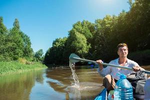 Man in kayak trip rowing boat on the river, a water hike, a summer adventure. Eco-friendly and extreme tourism, active and healthy lifestyle photo