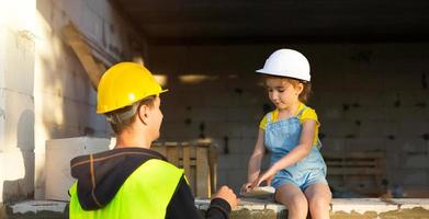 papá e hija están en el sitio de construcción de su futuro hogar. la elección de la futura profesión de constructor la hereda el hijo. la expectativa de mudarse, el sueño de una casa. préstamo hipotecario foto