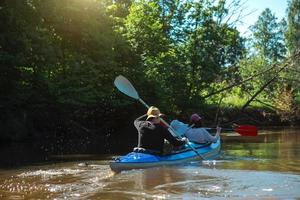 hombre y mujer pareja en kayak familiar viaje bote de remos en el río, una caminata de agua, una aventura de verano. turismo ecológico y extremo, estilo de vida activo y saludable foto