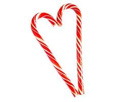 Two red striped candy canes of Santa are stacked in the shape of a heart on white background. Isolate, frame. Christmas, new year, Valentine's day, winter holiday atmosphere for lovers and loved ones photo