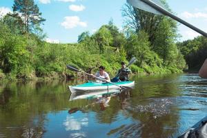 viaje familiar en kayak. una pareja de ancianos casados remando un bote en el río, una caminata acuática, una aventura de verano. deportes relacionados con la edad, salud y juventud mental, turismo, vejez activa foto