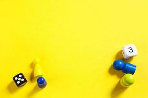 Layout of board games on a yellow background dice, chips, hourglass timer. Entertainment at home for children and adults. Copy space photo