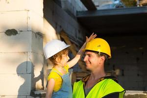 papá e hija están en el sitio de construcción de su futuro hogar. la elección de la futura profesión de constructor la hereda el hijo. la expectativa de mudarse, el sueño de una casa. préstamo hipotecario foto