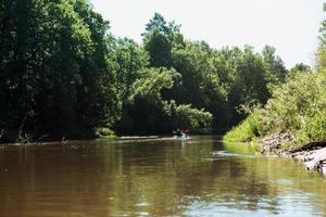 Man and woman couple in family kayak trip rowing boat on the river, a water hike, a summer adventure. Eco-friendly and extreme tourism, active and healthy lifestyle photo