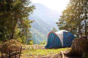 Installed tourist tent in a camping in nature in the forest. Domestic tourism, active summer holidays, family adventures. Ecotourism, sport, hike. Copy space, mock up photo