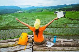 naturaleza de viaje de mujer asiática. viajar relajarse. de pie leyendo un libro en el balcón de la casa. en verano. foto