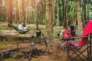 mujeres asiáticas viajes naturales relajarse en las vacaciones. sentado leyendo un libro en la hamaca. acampando en el parque nacional doi inthanon en chiangmai. En Tailandia foto