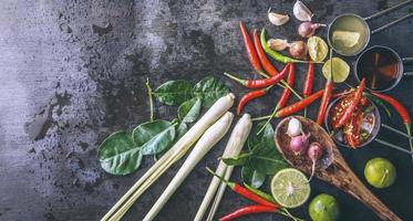 especias para usar como ingredientes de cocina sobre un fondo de madera con verduras frescas. hierbas de alimentos saludables. verduras orgánicas en la mesa. materias primas de cocina preparacion tom yum. foto