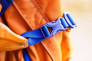 Close-up detail of locked blue convenient plastic clasp of backpack yellow. photo