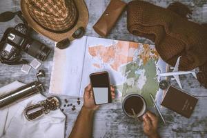 Tourist planning vacation with the help of world map and compass along and Coffee cup with coffee grinder with other travel accessories. Preparing for travel. Travel planning concept holiday with map photo
