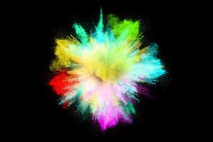explosión de polvo de colores, aislado sobre fondo negro foto