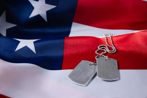 concepto del día conmemorativo de estados unidos. bandera americana y placas de identificación militares. foto